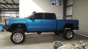 Custom-lifted blue pickup truck