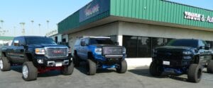 Three pickup trucks with suspension lifts