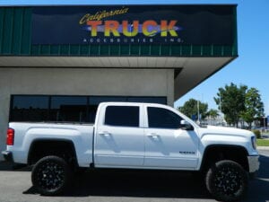 Side view of a suspension-lifted white pickup truck