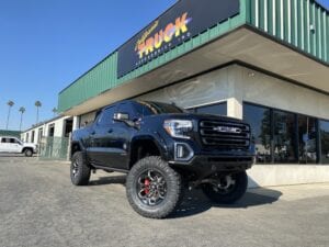 Black pickup truck parked in front of the California Truck Accessories shop