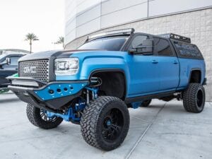 Blue GMC truck with custom parts and suspension lifts